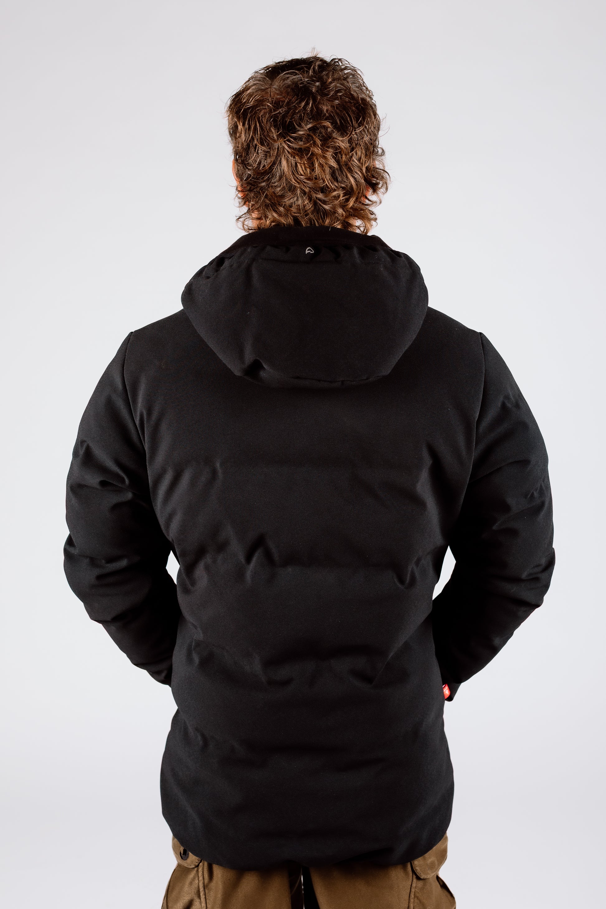 Person wearing a black jacket with a hood on a white background